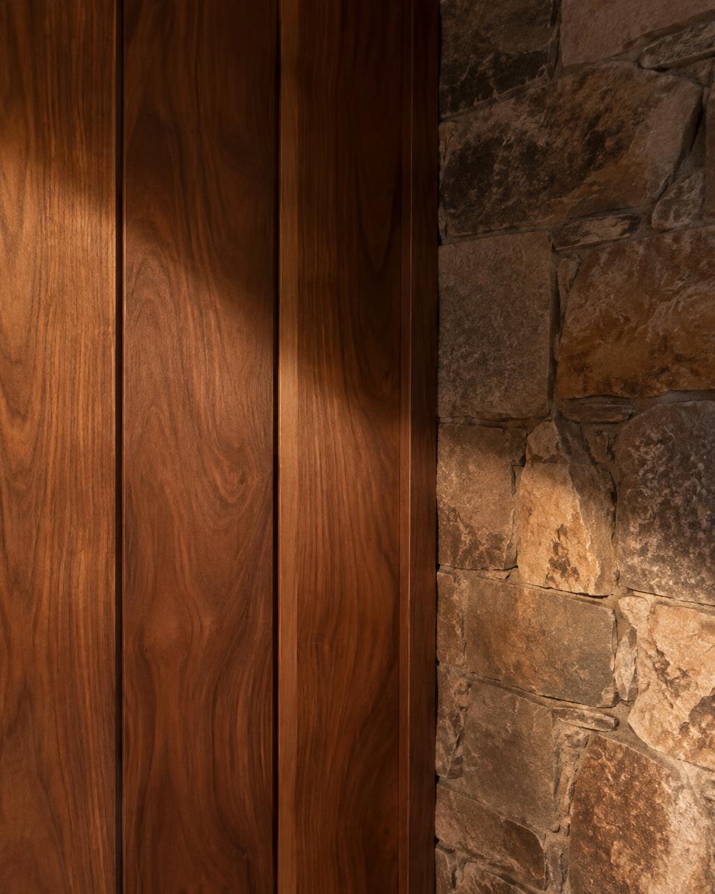 Walnut panelling meeting a stone wall