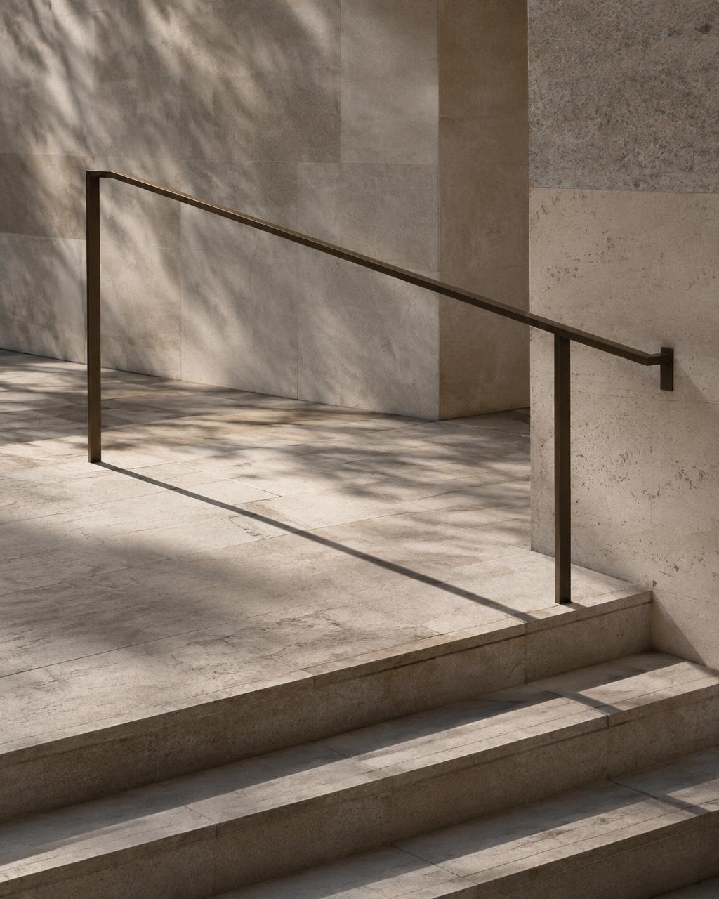Stone stair landing with a bronze handrail