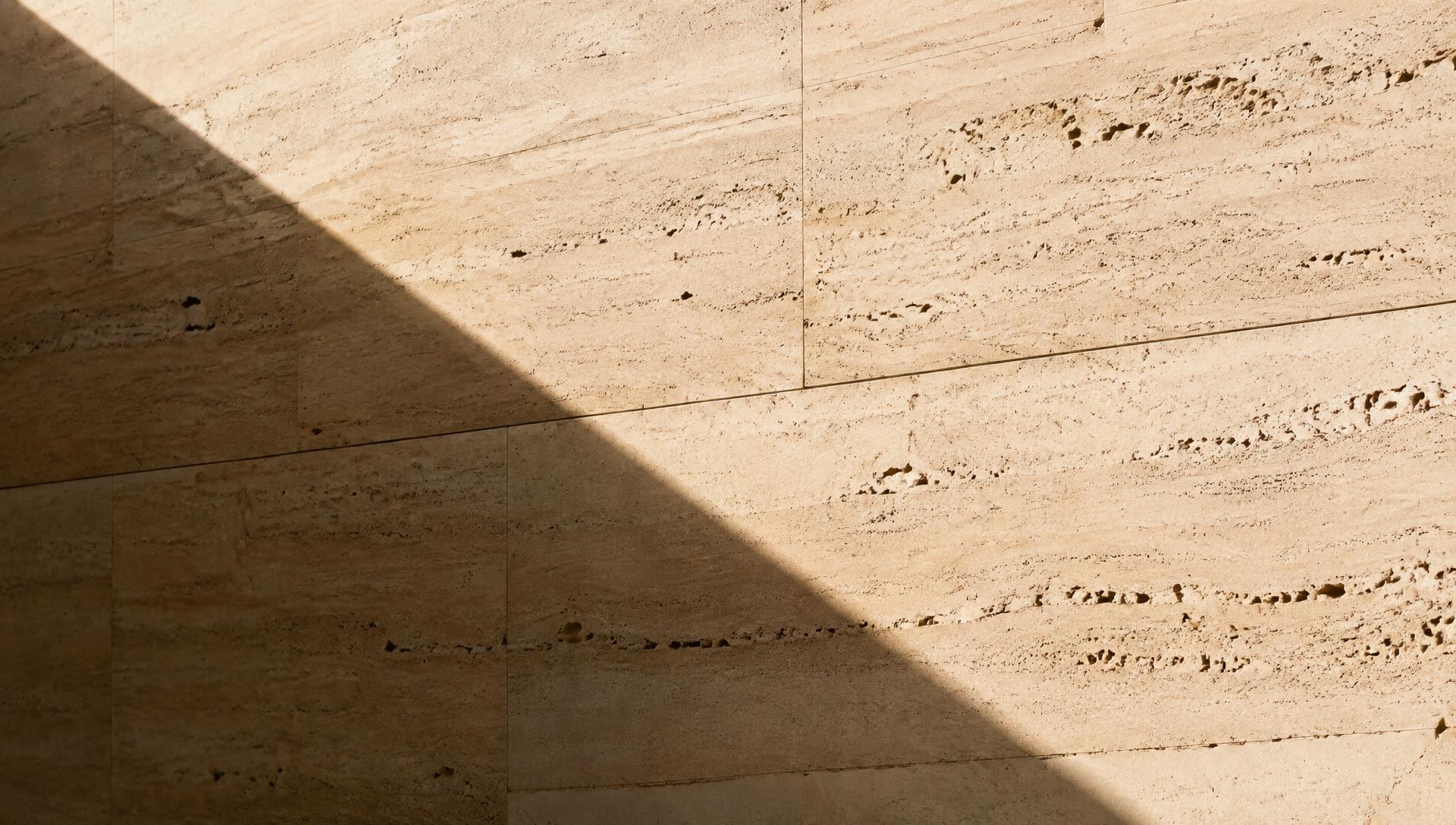 Travertine wall crossed by a strong architectural shadow