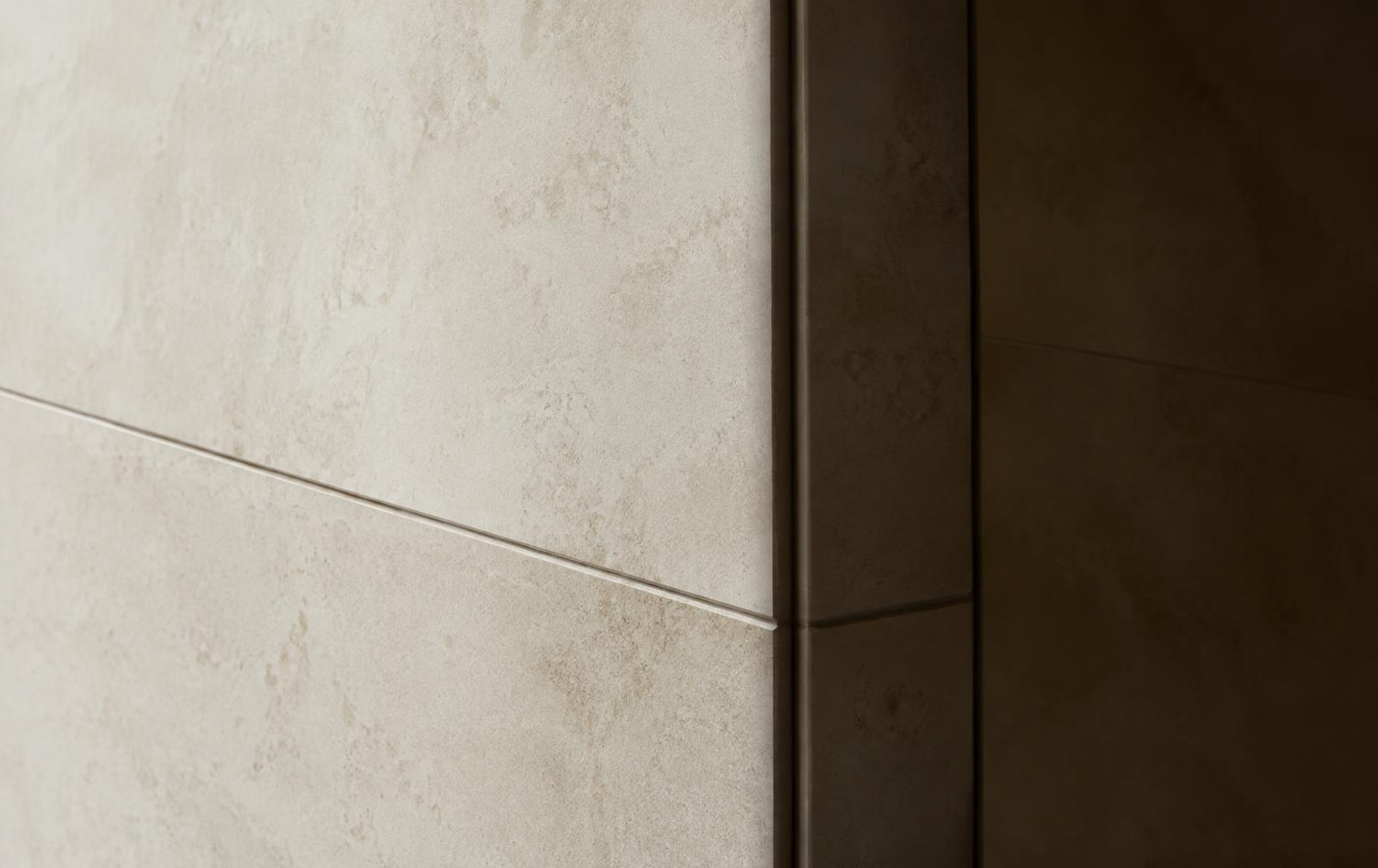 Limestone wall meeting a dark bronze joint